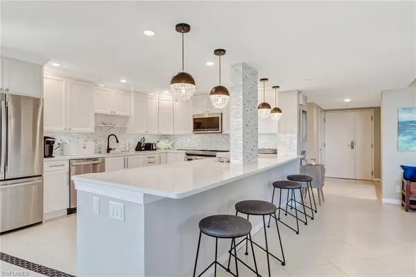 a kitchen with a sink a counter space appliances and cabinets