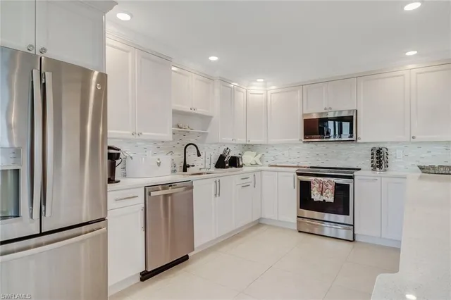 a kitchen with white cabinets and stainless steel appliances