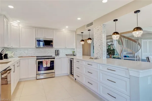 a kitchen with granite countertop white cabinets and white appliances