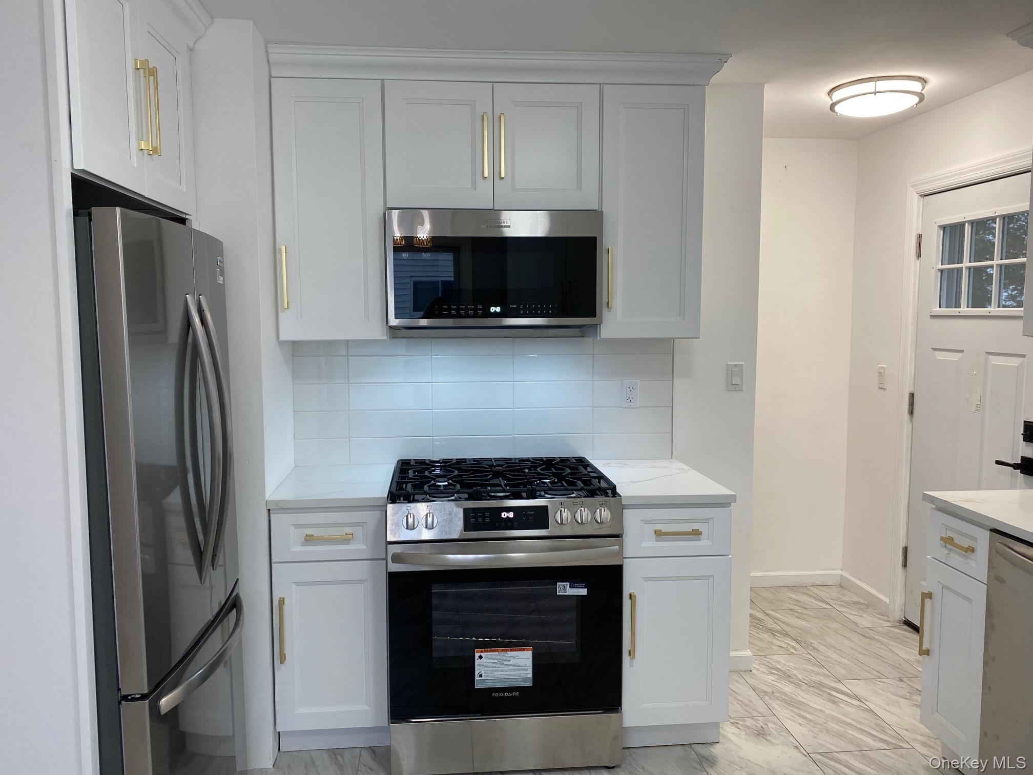 5 Smith Road Cornwall, NY 12518 - Photo 9 of 32 Kitchen with appliances with stainless steel finishes, backsplash, light marble finish floors, and white cabinets