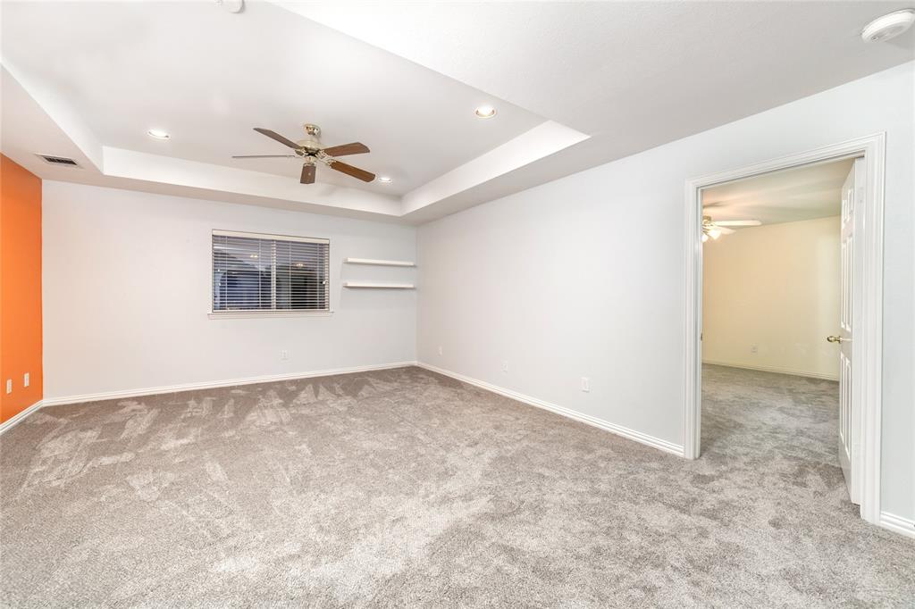 5801 Yeary Road Plano, TX 75093 - Photo 21 of 33 Spacious room featuring tray ceilings with recessed lighting, a ceiling fan, and carpet flooring