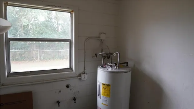 a view of a backyard with large trees and a barn