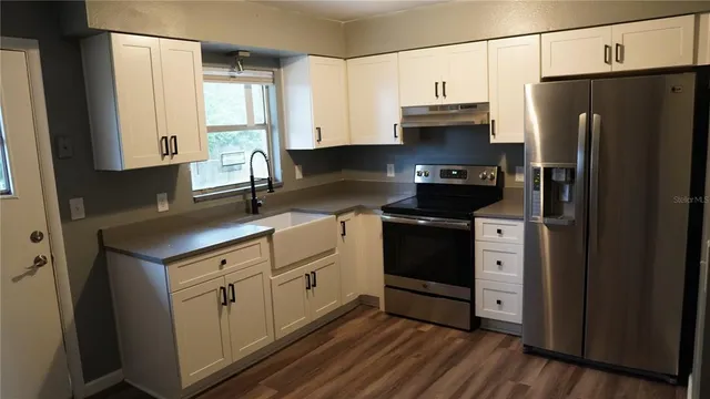 a kitchen with stainless steel appliances a refrigerator sink and cabinets