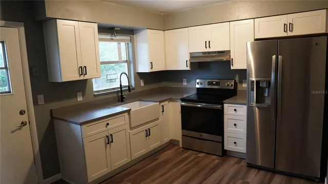 a kitchen with stainless steel appliances a refrigerator sink and cabinets