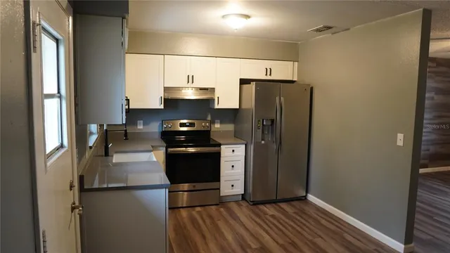 a kitchen with stainless steel appliances a refrigerator and a stove top oven