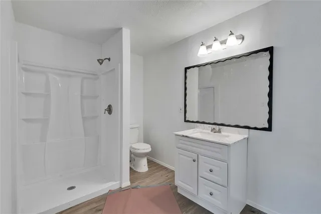 a bathroom with a toilet sink a mirror a lamp and vanity