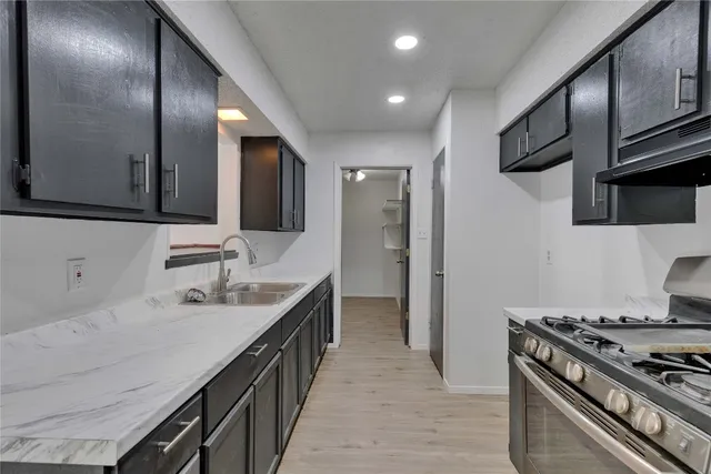a kitchen with stainless steel appliances a sink stove and cabinets