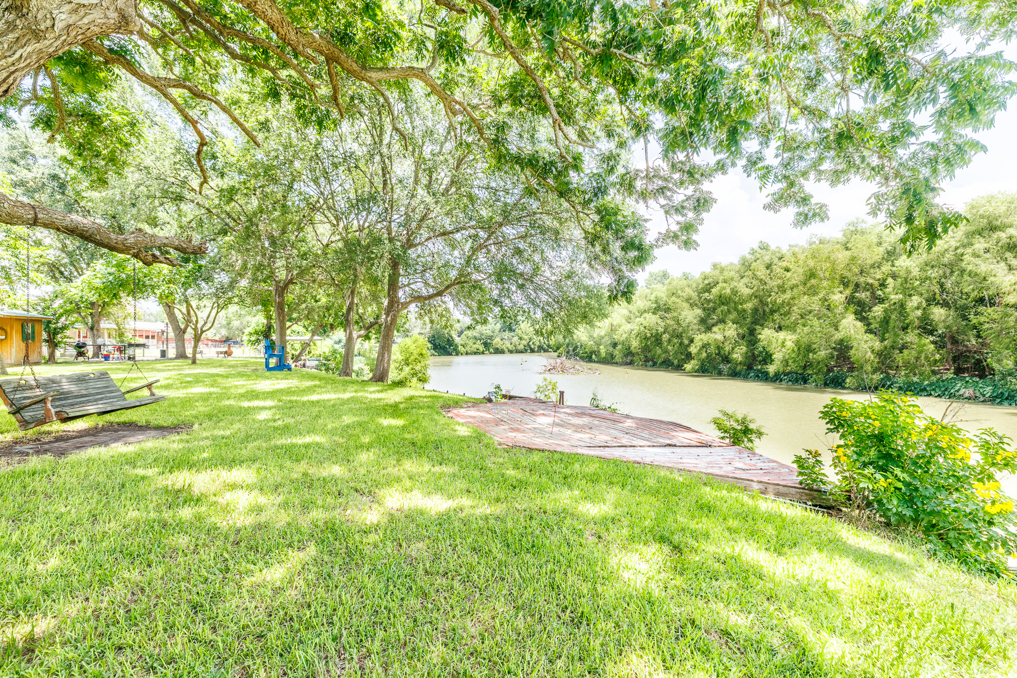 Tbd Goodwin Road Gonzales, TX 78629 - Photo 9 of 33 A tranquil riverside setting with a private dock and lush greenery invites peaceful relaxation.