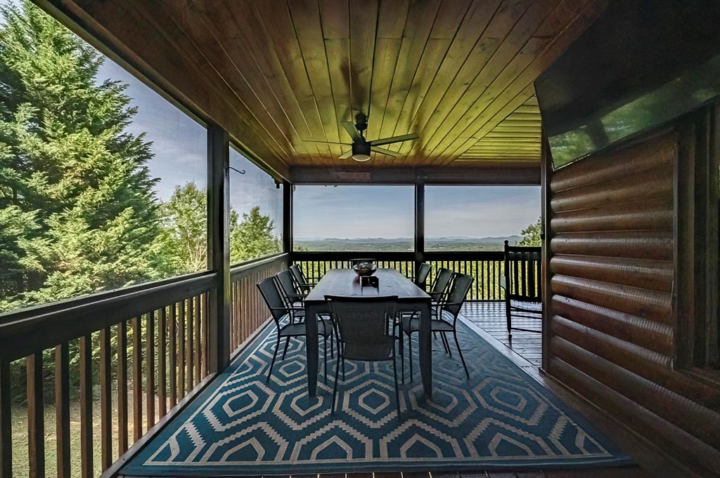 1722 Sun Rock Mountain Road Blue Ridge, GA 30513 - Photo 2 of 67 a view of a patio with table and chairs with wooden floor and fence