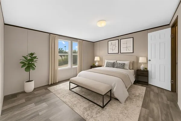 a bedroom with a large bed and a potted plant