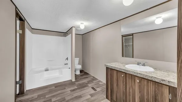 a bathroom with a granite countertop sink mirror and shower