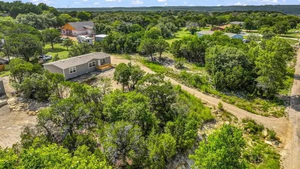 an aerial view of residential house with outdoor space and trees all around
