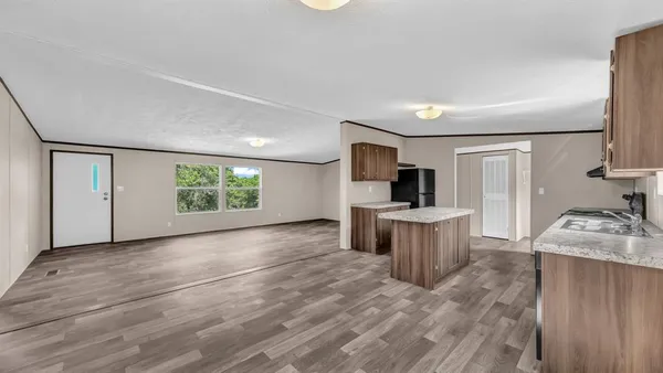 a view of a kitchen with a sink wooden floor and a window
