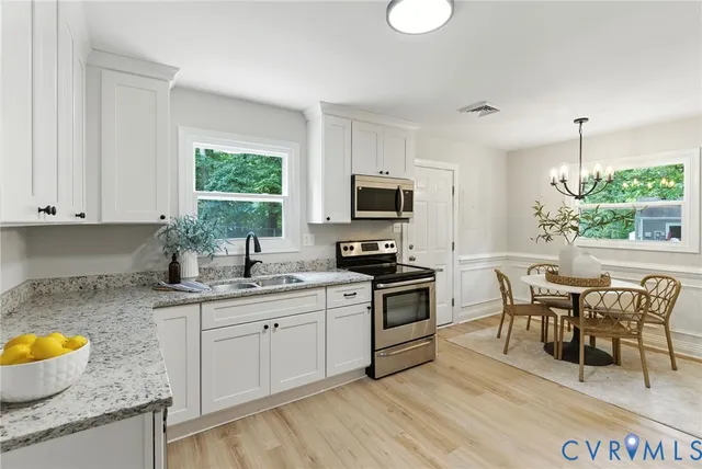 a kitchen with granite countertop a sink appliances cabinets and furniture