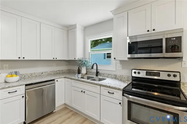 a kitchen with cabinets stainless steel appliances and a sink