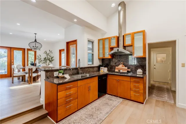a kitchen with stainless steel appliances granite countertop a sink a stove and a wooden floors