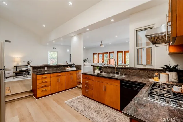 a kitchen with stainless steel appliances granite countertop a stove a sink and a refrigerator