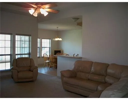 a living room with furniture a large window and a chandelier