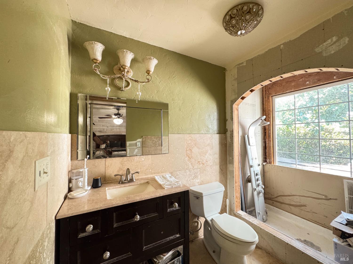 4400 Lake Ridge Road Ukiah, CA 95482 - Photo 40 of 78 a bathroom with a toilet a sink a tub and mirror