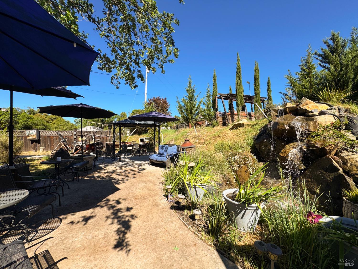 4400 Lake Ridge Road Ukiah, CA 95482 - Photo 47 of 78 a view of a patio with chairs and table under an umbrella