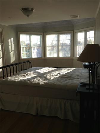 126 Summer Street, Unit 126 Watertown, MA 02472 - Photo 18 of 30 a view of a bedroom with a bed and wooden floor