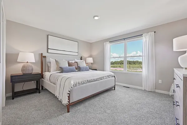 a spacious bedroom with a bed and a window