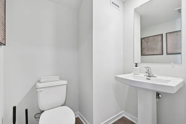 a bathroom with a toilet a sink and mirror