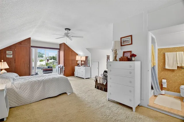 a bedroom with bed and white cabinets