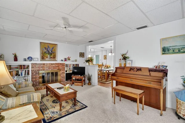 a living room with furniture a fireplace and paintings on the wall