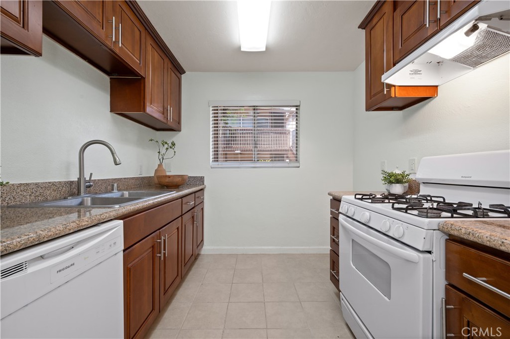 1044 Cabrillo Park Drive, Unit B Santa Ana, CA 92701 - Photo 11 of 49 a kitchen with stainless steel appliances granite countertop a sink stove and microwave