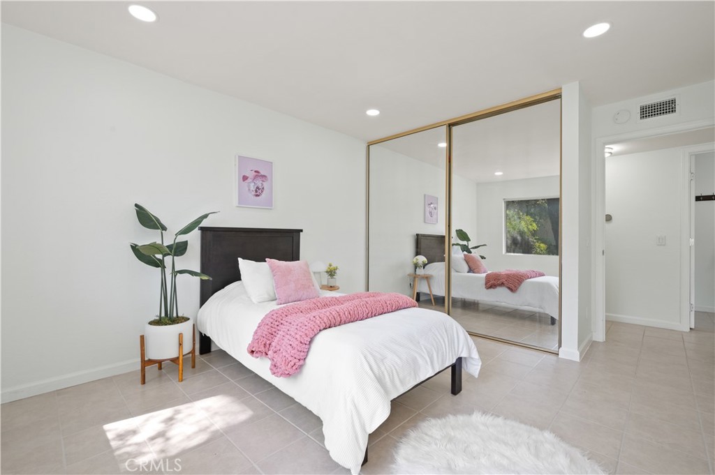 1044 Cabrillo Park Drive, Unit B Santa Ana, CA 92701 - Photo 17 of 49 a spacious bedroom with a bed and a large mirror