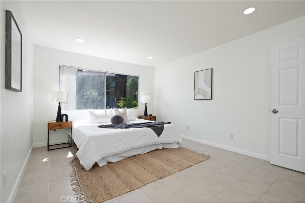 1044 Cabrillo Park Drive, Unit B Santa Ana, CA 92701 - Photo 21 of 49 a bedroom with a bed and a large window