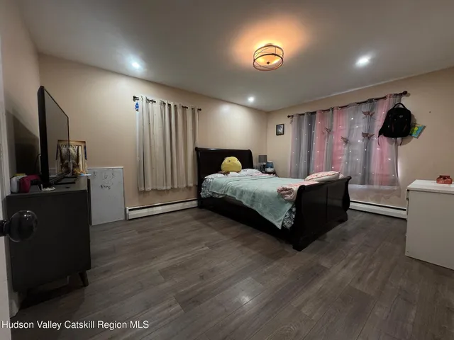 a spacious bedroom with a bed and a flat screen tv