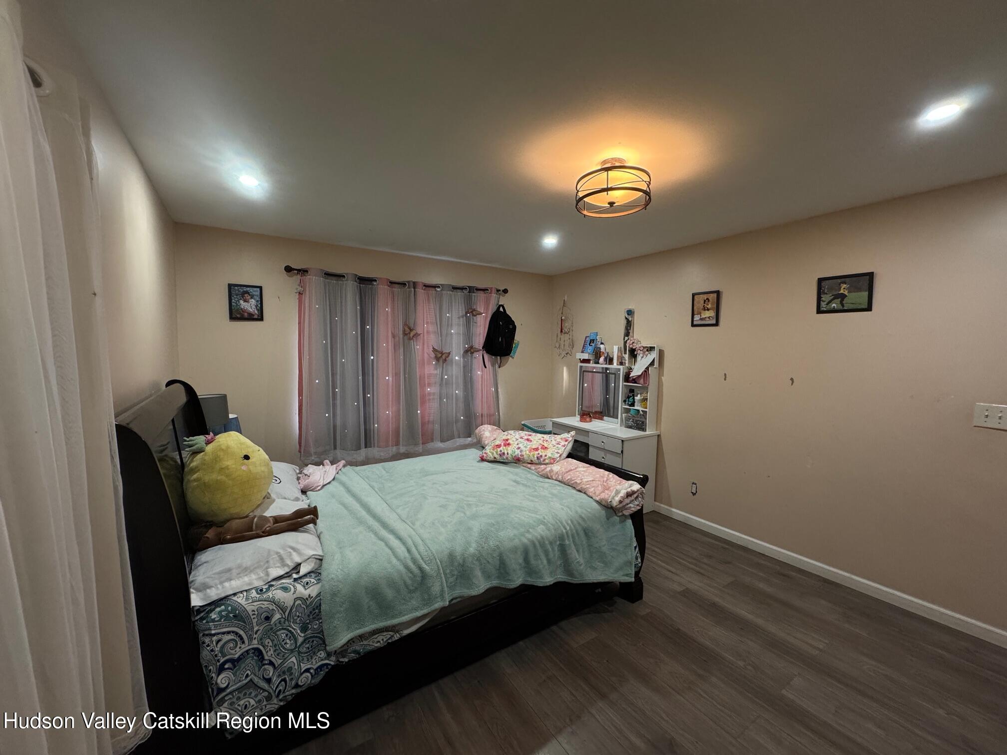 2 Spaulding Lane Saugerties, NY 12477 - Photo 16 of 24 a bedroom with a bed and a lamp with wooden floor