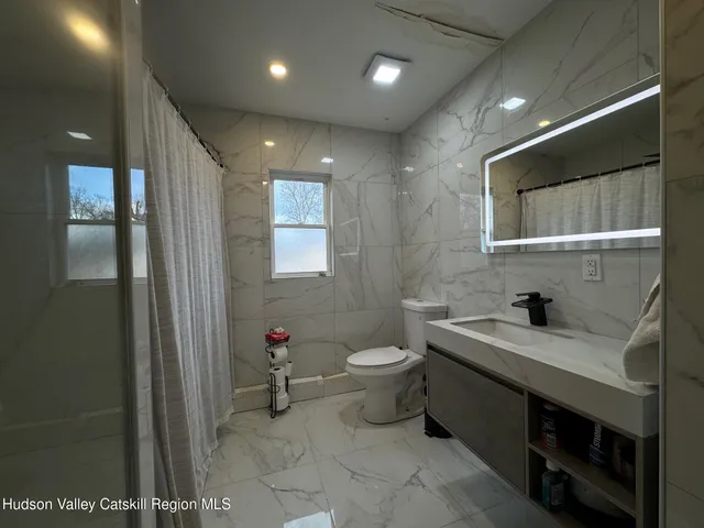a bathroom with a toilet sink and mirror