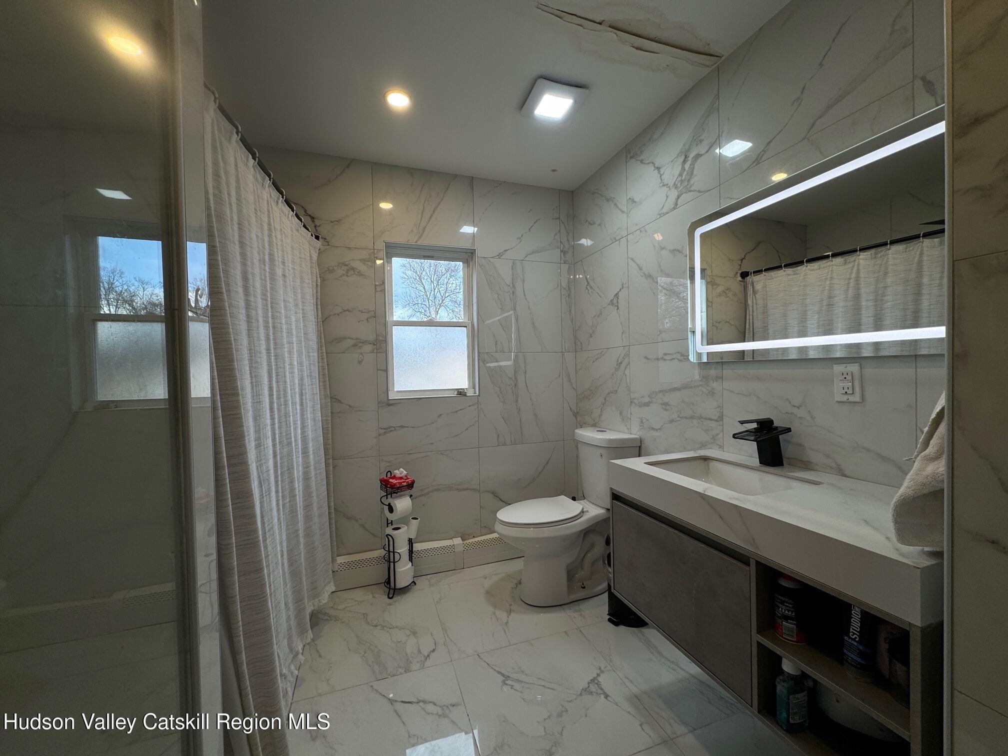 2 Spaulding Lane Saugerties, NY 12477 - Photo 17 of 24 a bathroom with a toilet sink and mirror