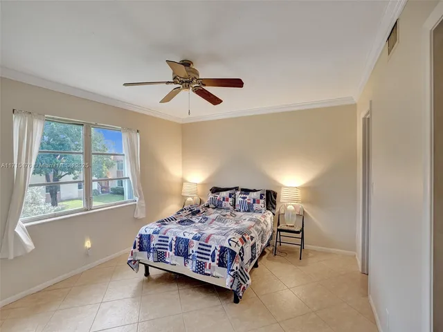 a bedroom with a bed chandelier and a window