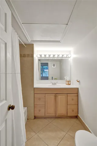 a bathroom with a granite countertop sink mirror vanity and toilet