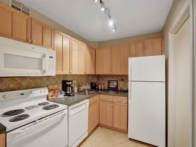 a kitchen with a white cabinets and white appliances