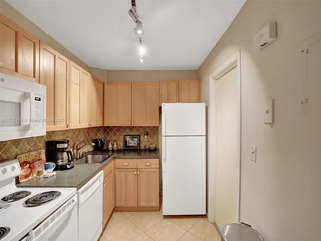 a kitchen with sink a refrigerator and cabinets