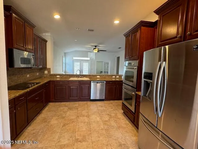 a kitchen with stainless steel appliances granite countertop a refrigerator a sink a stove a microwave and island