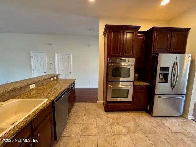 a kitchen with granite countertop a refrigerator and a stove