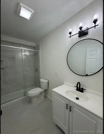 a bathroom with a sink mirror and toilet