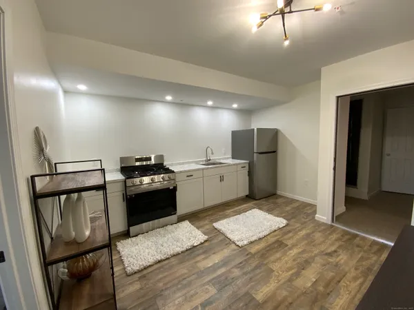 a kitchen with stainless steel appliances kitchen island a stove a refrigerator and a sink