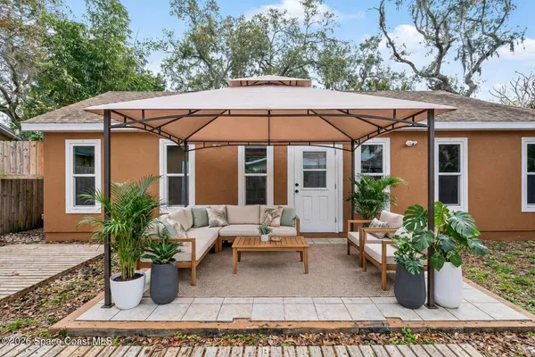a view of a house with backyard sitting area and porch