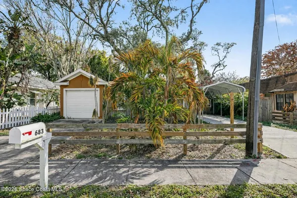 a front view of a house with a yard and tree s