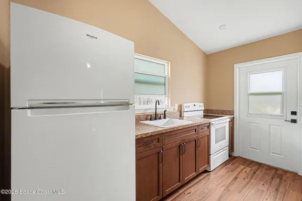 a kitchen with a sink a stove a refrigerator and cabinets