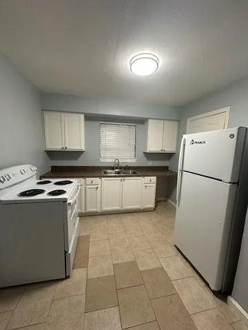 a kitchen with a stove a refrigerator and a sink