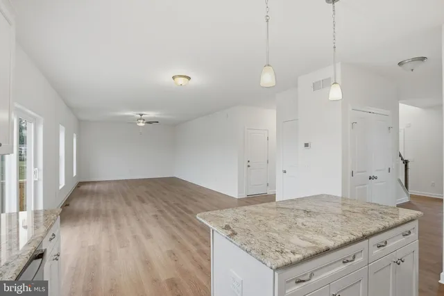 a view of a kitchen island a sink dishwasher and a fireplace with wooden floor