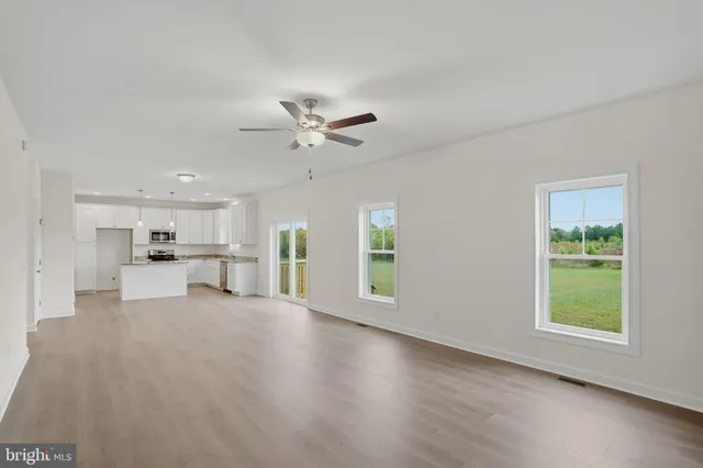 a view of a kitchen with furniture ceiling fan and window